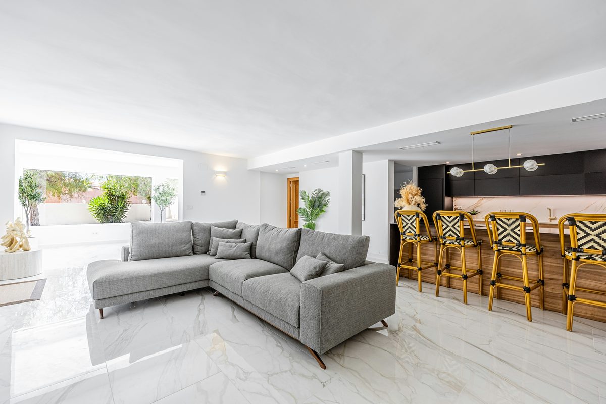 A whitewashed Mediterranean villa exterior with shutters opening for the season.
